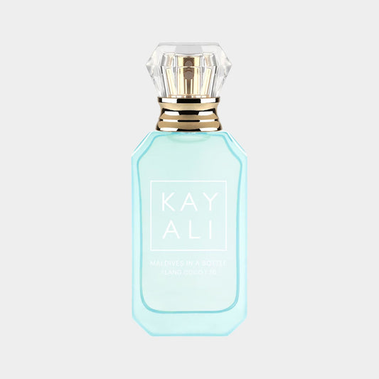 A turquoise bottle of Kayali Maldives In A Bottle Ylang Coco 20, featuring a diamond-shaped cap and elegant branding. The fragrance is designed to evoke a tropical paradise experience.