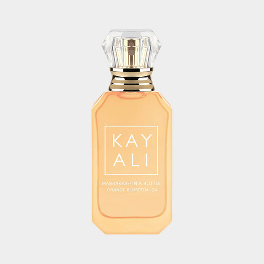 A sample bottle of Kayali Marrakesh in A Bottle Orange Blossom 24, featuring an elegant design with a golden cap and a peach-colored fragrance. The label prominently displays the brand name and scent details.
