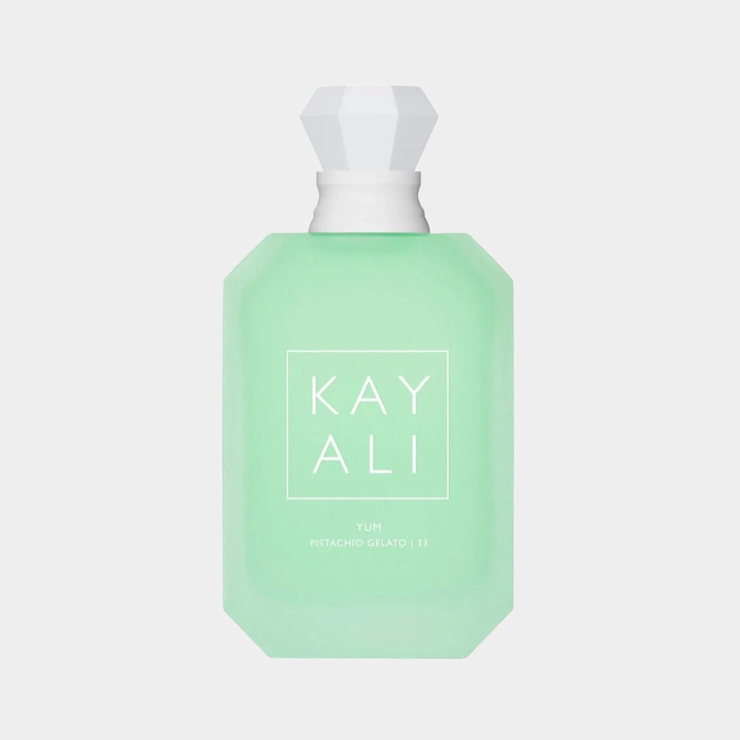 A green fragrance bottle labeled Kayali Yum Pistachio Gelato 33 Sample, featuring a sleek hexagonal design and a faceted cap.