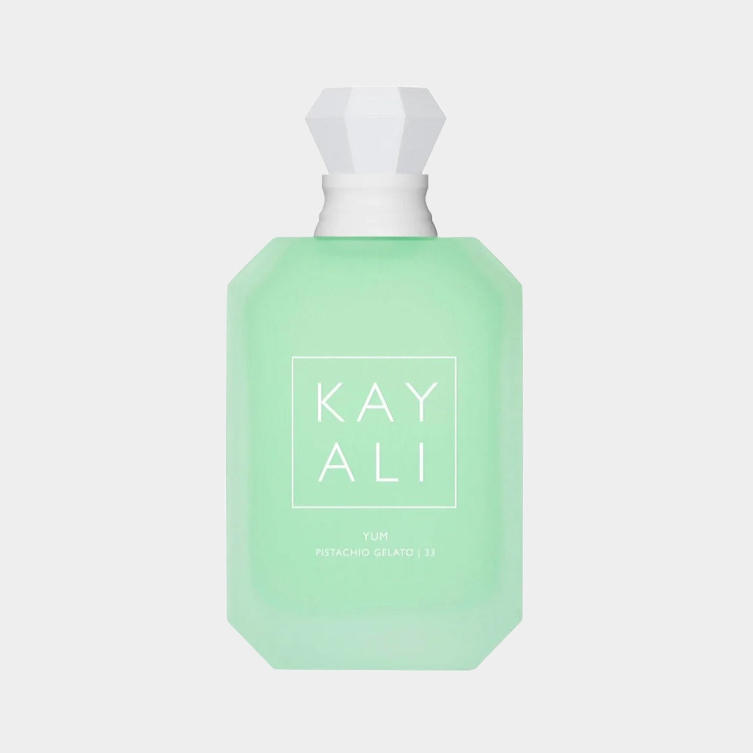 A green fragrance bottle labeled Kayali Yum Pistachio Gelato 33 Sample, featuring a sleek hexagonal design and a faceted cap.