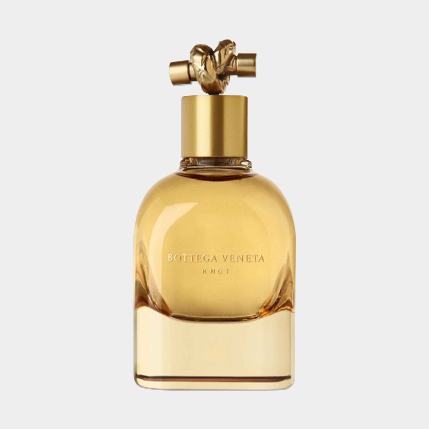 A Bottega Veneta Knot Sample fragrance bottle featuring a rounded glass design with a gold cap adorned by a decorative knot, showcasing a warm golden liquid inside.