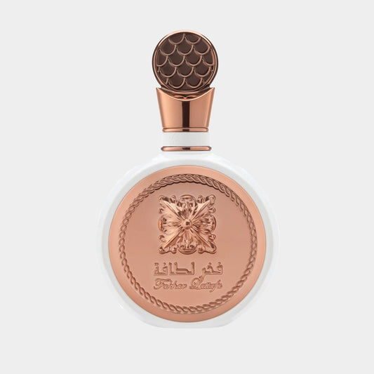 A beautifully designed bottle of Lattafa Perfumes Fakhar Rose Sample, featuring a white base and an ornate copper lid with intricate detailing. The elegant label showcases the brand name prominently.