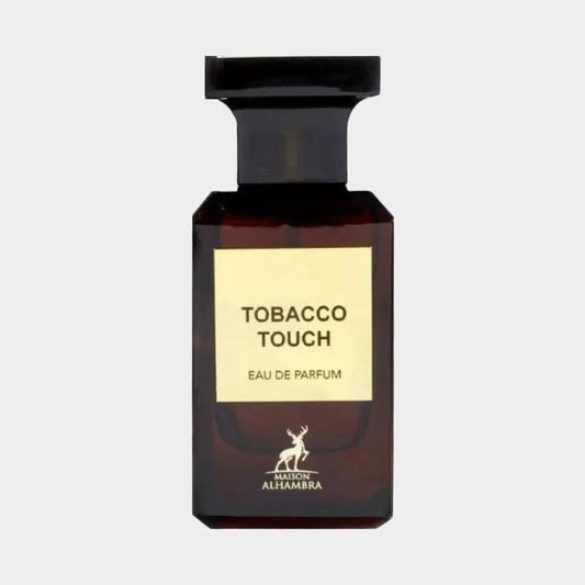 A close-up of the Maison Alhambra Tobacco Touch sample bottle, featuring a dark amber glass design with a label that reads TOBACCO TOUCH and Eau de Parfum. The elegant bottle is topped with a sleek black cap.
