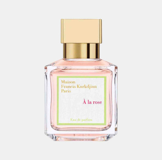 A Maison Francis Kurkdjian À La Rose sample bottle featuring a delicate pink fragrance in a clear glass container, topped with a gold cap. The label showcases the brand and perfume name in elegant lettering.