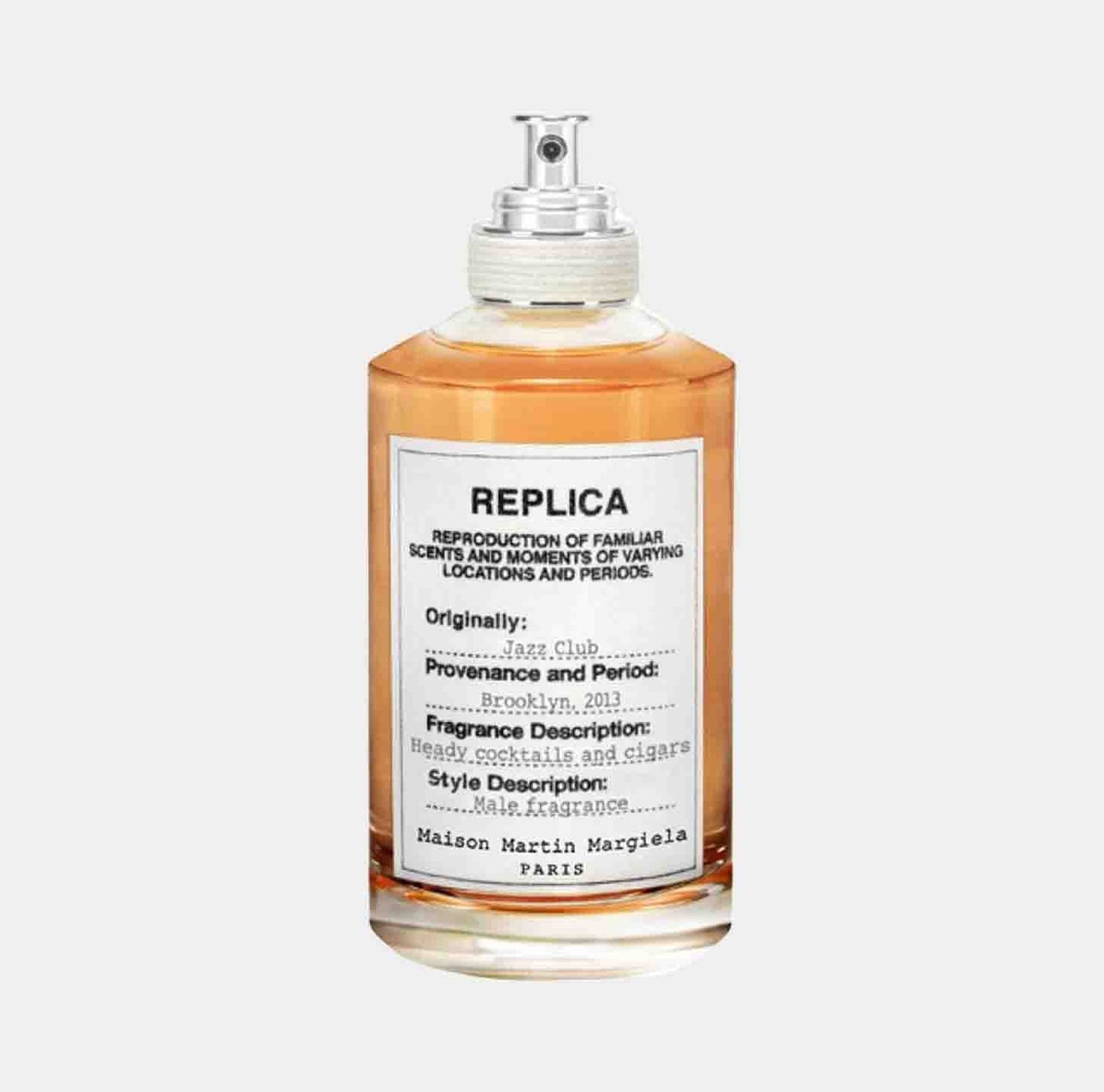 A glass bottle of Maison Martin Margiela Replica Jazz Club Sample, featuring a label that describes its fragrance as reminiscent of heavy cocktails and cigars, originally inspired by a jazz club in Brooklyn, 2013.