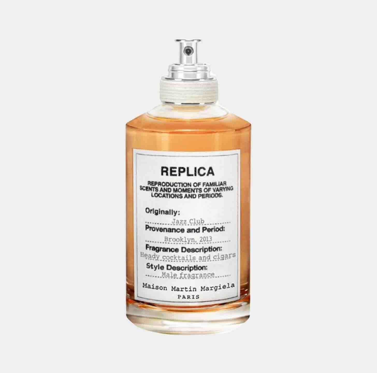 A glass bottle of Maison Martin Margiela Replica Jazz Club Sample, featuring a label that describes its fragrance as reminiscent of heavy cocktails and cigars, originally inspired by a jazz club in Brooklyn, 2013.