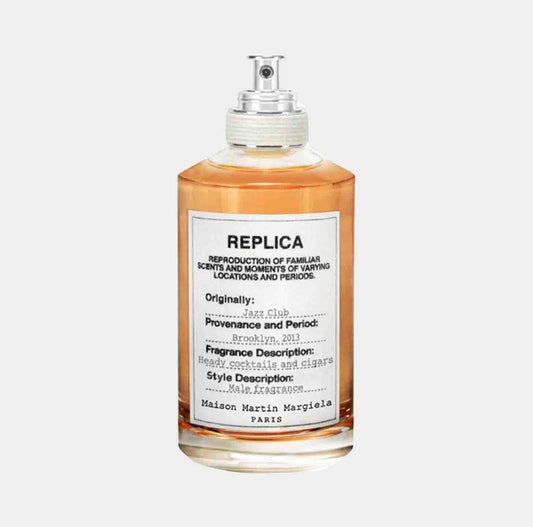 A glass bottle of Maison Martin Margiela Replica Jazz Club Sample, featuring a label that describes its fragrance as reminiscent of heavy cocktails and cigars, originally inspired by a jazz club in Brooklyn, 2013.
