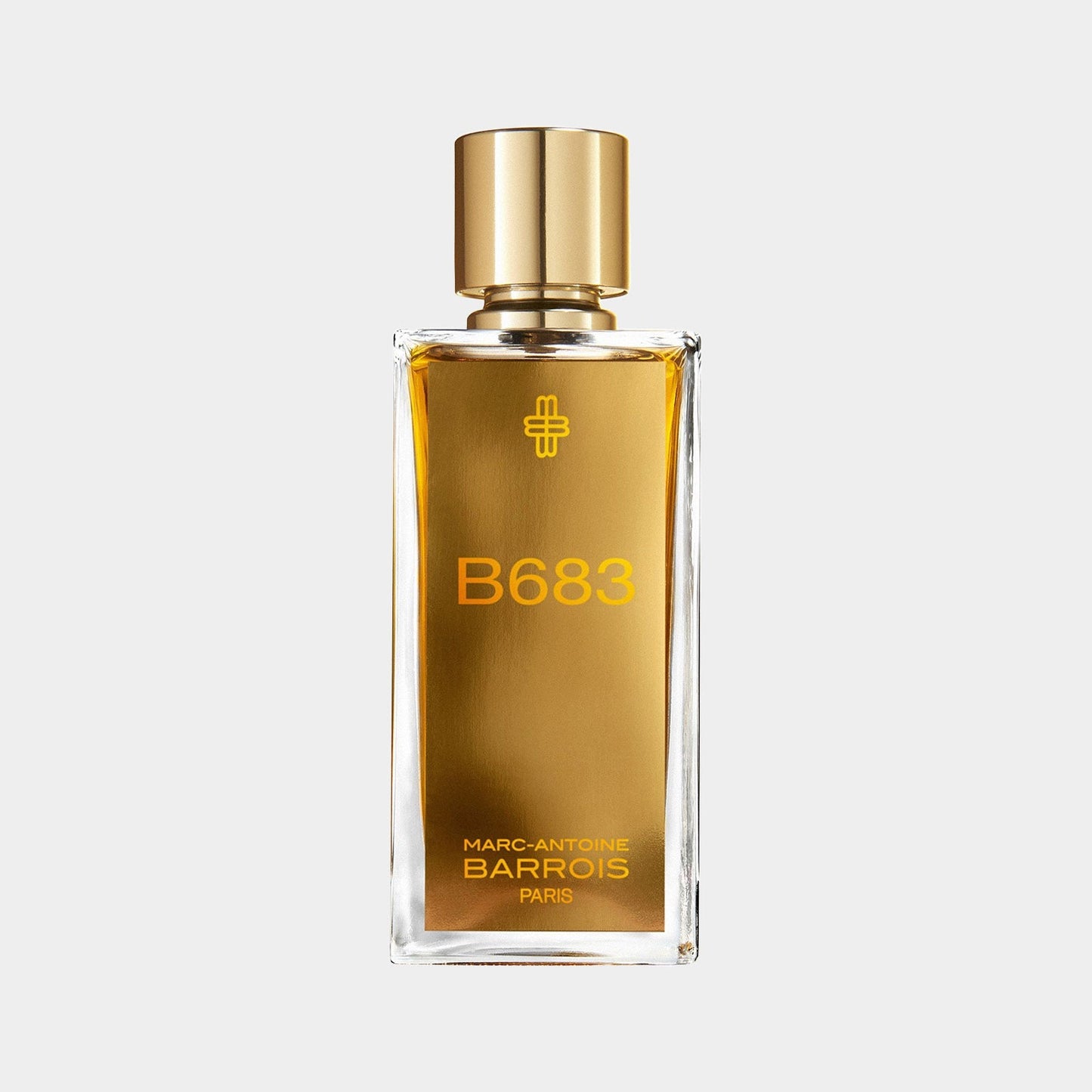 A sleek glass bottle of Marc-Antoine Barrois B683 perfume, featuring a gold cap and a label with a bold orange font, showcasing an elegant and sophisticated design.