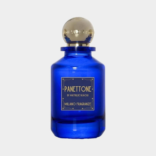 A deep blue bottle of Milano Fragranze Panettone Sample, featuring an elegant gold cap and a label that details the fragrance by Mathilde Bijaoui. The bottle's classic design highlights its luxurious essence.