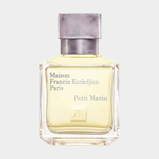 A sample bottle of Maison Francis Kurkdjian Petit Matin, featuring a sleek glass design with a silver cap and light yellow fragrance. The label includes the brand name and fragrance title in elegant font.