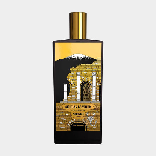 A sleek black bottle of Memo Paris Sicilian Leather fragrance featuring intricate gold artwork depicting architectural elements. The design embodies the essence of Sicilian luxury with a bold golden cap.