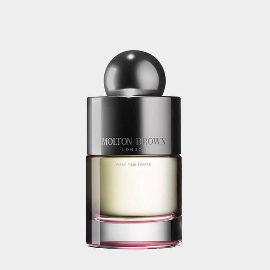 A sleek, modern bottle of Molton Brown Fiery Pink Pepper EDT Sample, featuring a metallic cap and a clear glass base with a hint of pink at the bottom. The bottle showcases the distinctive branding of Molton Brown, highlighting its luxurious essence.