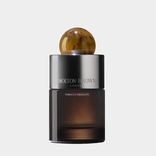 A sleek black glass bottle of Molton Brown Tobacco Absolute EDT, featuring an elegant amber-colored ball on the cap, showcasing the luxurious fragrance for men.