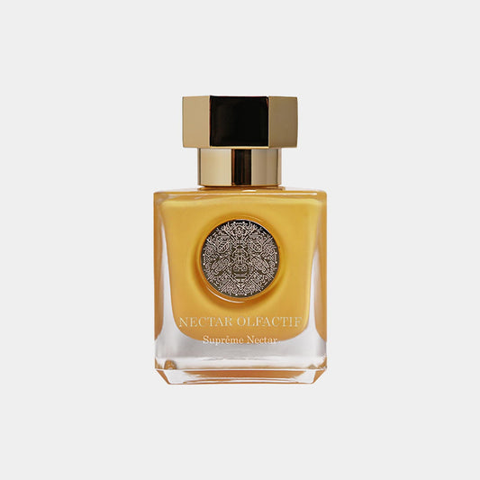 A luxurious glass bottle of Nectar Olfactif Suprême Nectar Sample, featuring a golden liquid and an ornate silver and black label, topped with a sophisticated gold cap.