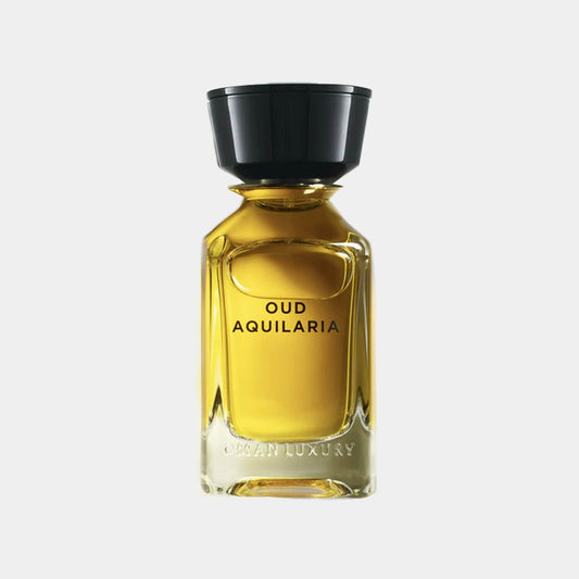A glass bottle of Omanluxury Oud Aquilaria, featuring a sleek design and a black cap, filled with a rich, golden fragrance.