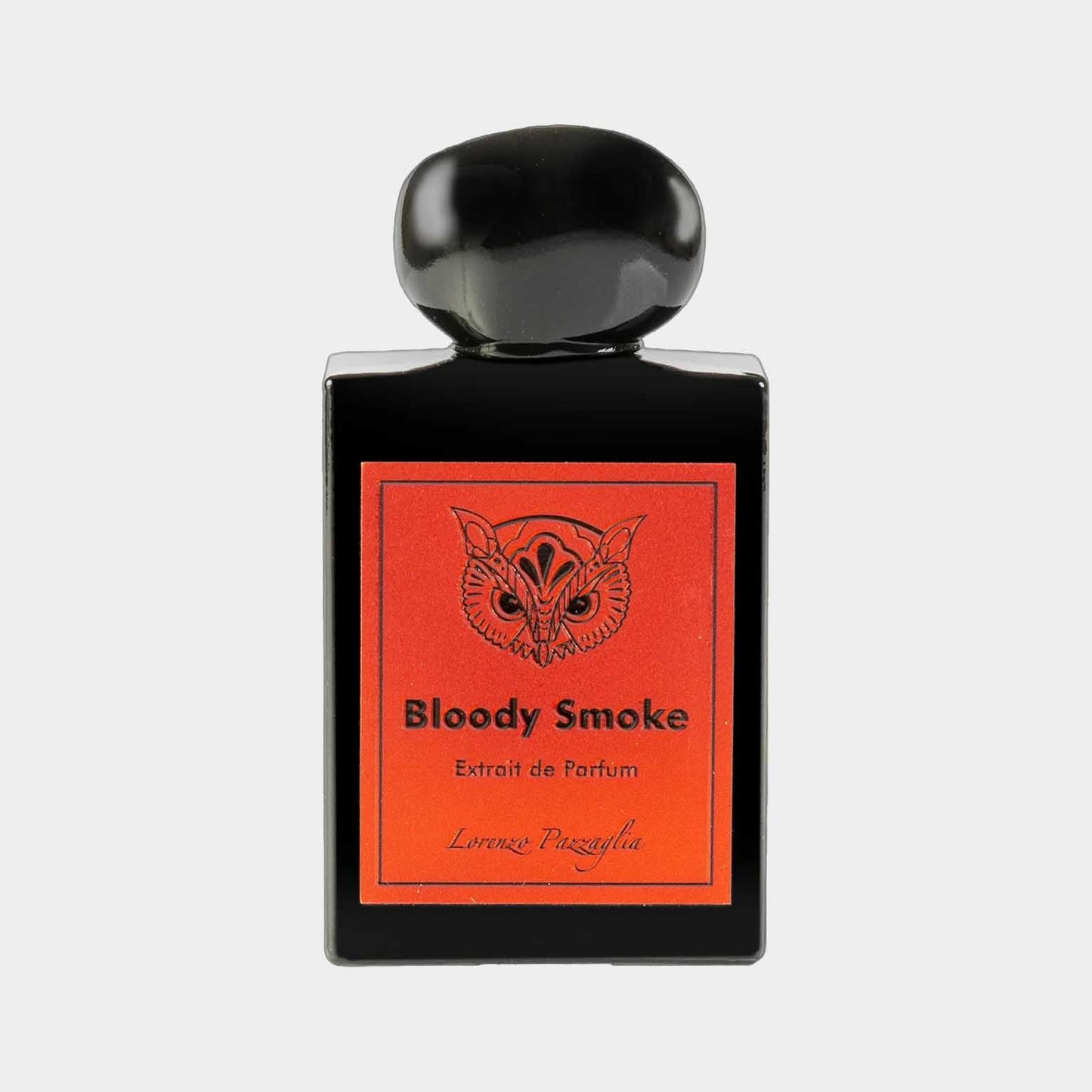 A sleek black perfume bottle with a round cap, featuring a vibrant red label that reads Bloody Smoke Extrait de Parfum by Lorenzo Pazzaglia. The design showcases a striking owl graphic, adding a unique touch to the packaging.