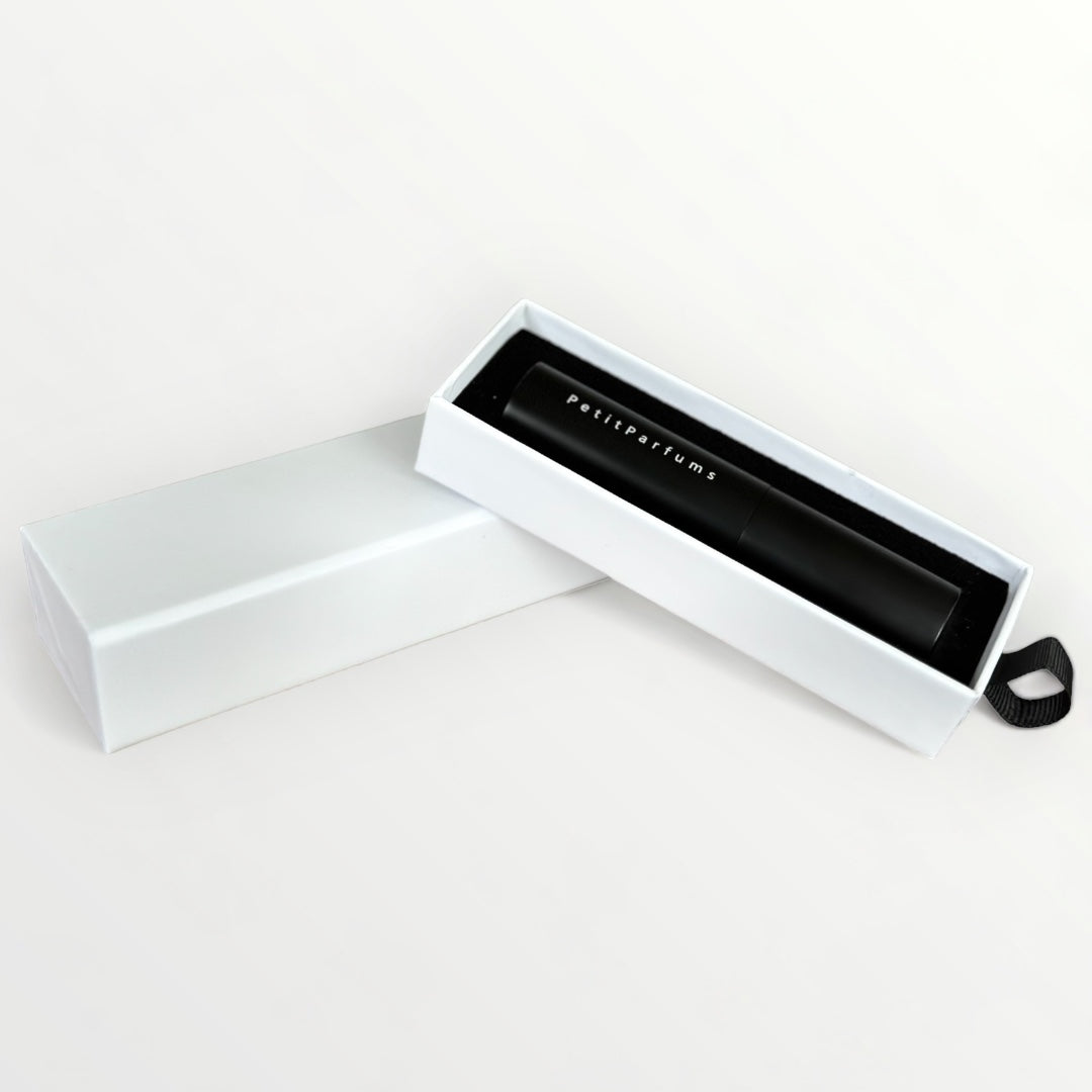 Cadeau verpakking - PetitParfums, featuring a sleek white box with a black cylindrical perfume bottle elegantly nestled inside.