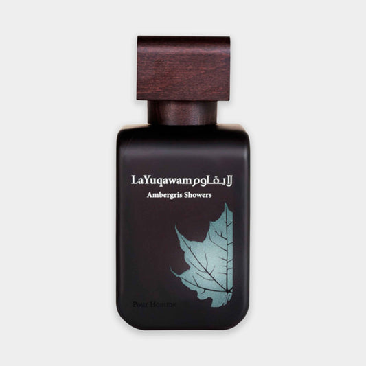 A sleek black bottle of Rasasi La Yuqawam Ambergris Showers, featuring an elegant wooden cap and a leaf-inspired design on the front. The fragrance is designed for men, exuding a luxurious scent profile.