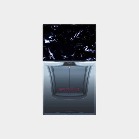 A sleek glass perfume bottle of Sora Dora Broceliande Sample, featuring a dark, marbled cap and a clear body that highlights the fragrance within. The label displays the name 'Broceliande' in elegant red lettering.
