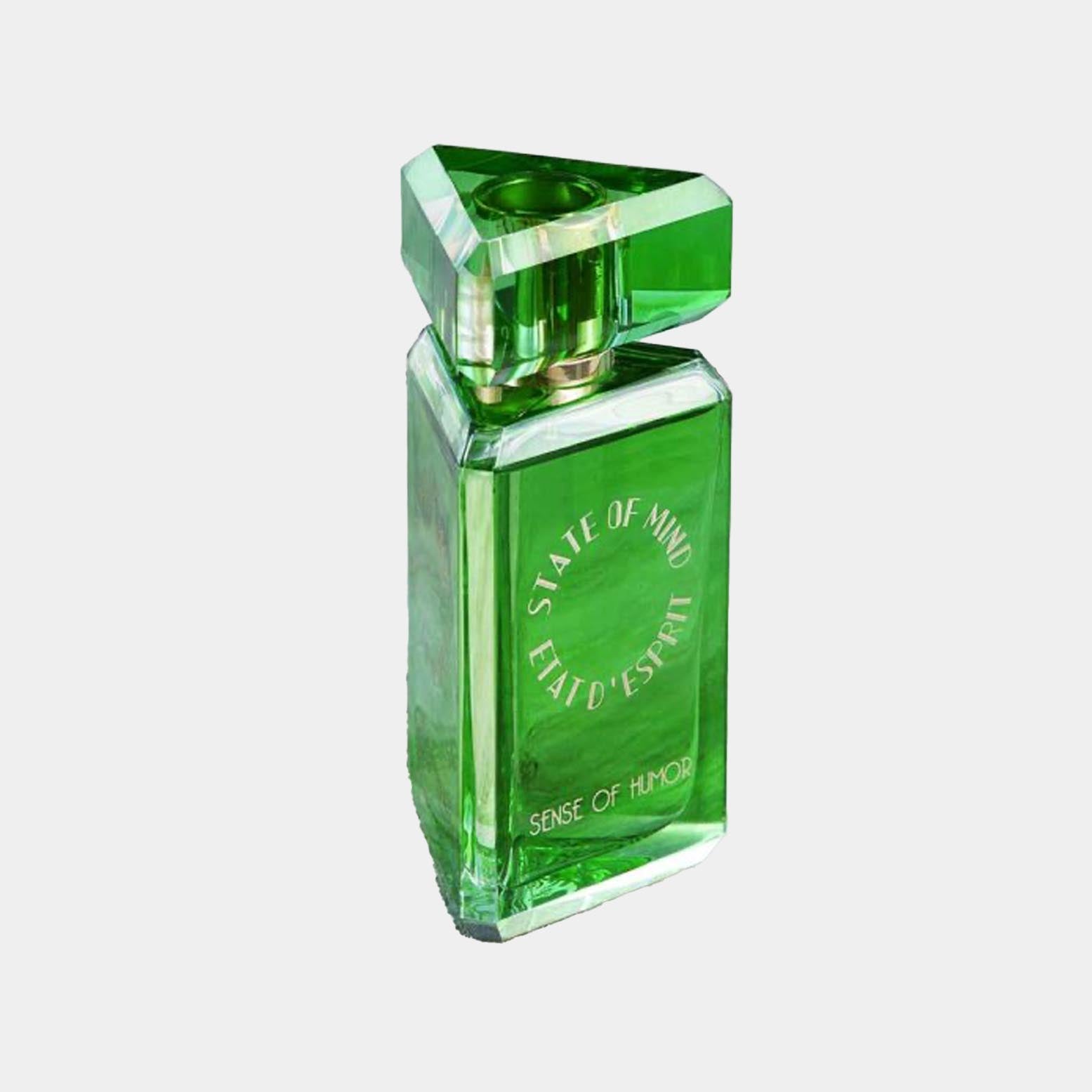 A green perfume bottle labeled State of Mind Sense of Humor Sample, featuring a unique triangular cap and a sleek rectangular design.