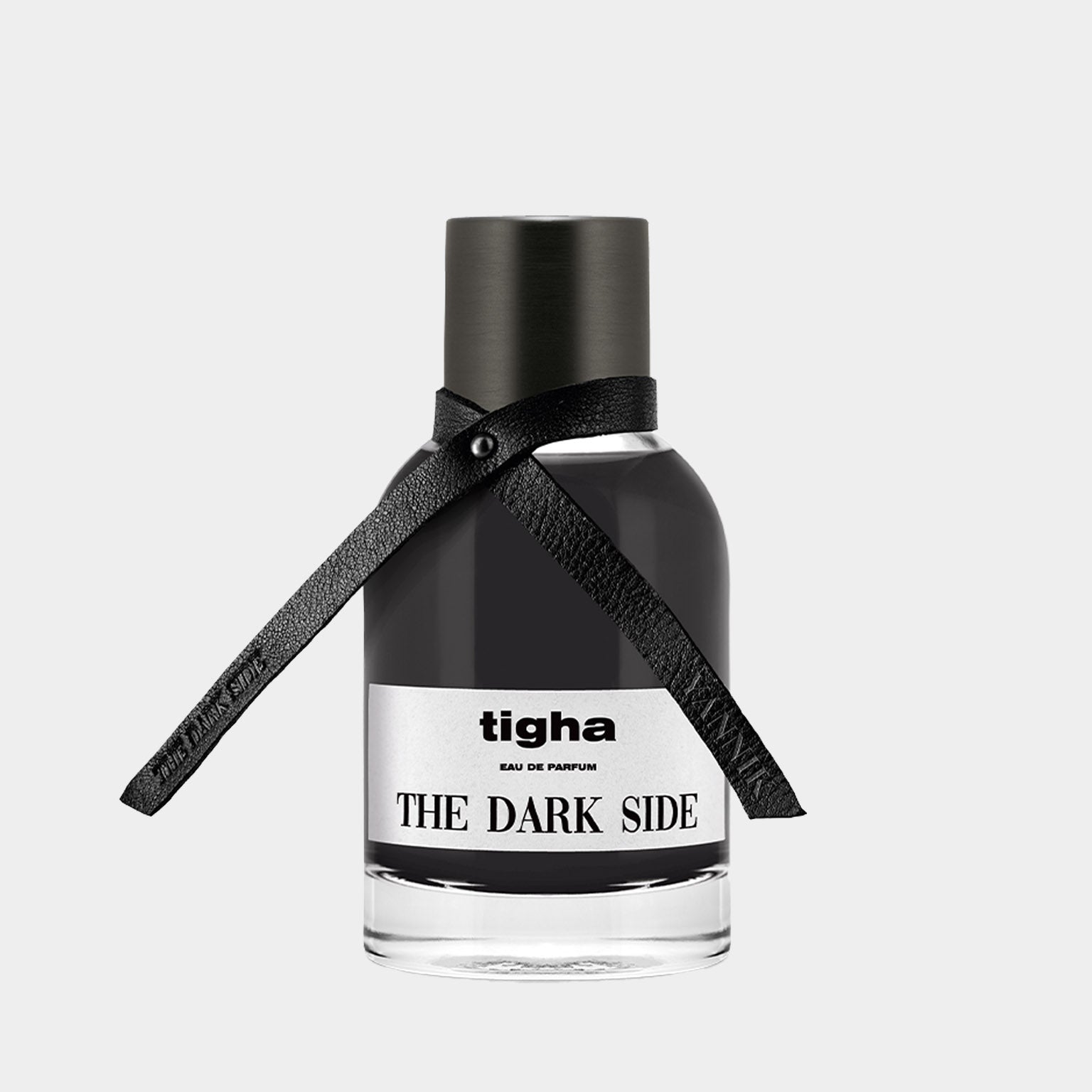 A sleek black perfume bottle labeled Tigha The Dark Side Sample, featuring an elegant leather ribbon around the neck, conveying a sense of mystery and sophistication.