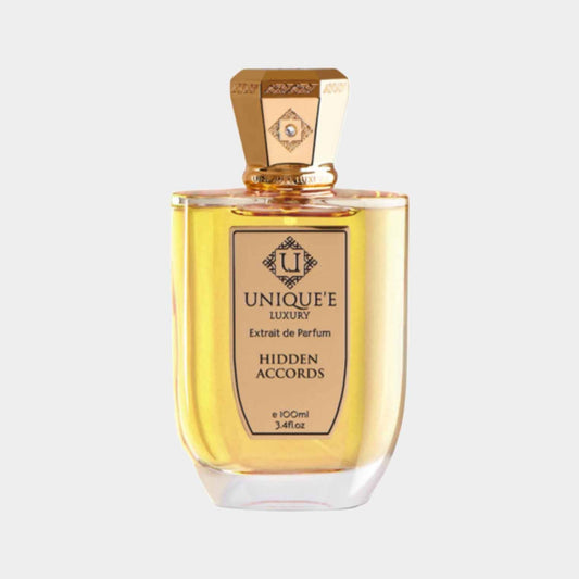 A bottle of Unique'e Luxury Hidden Accords Sample, showcasing a golden-yellow perfume in an elegant glass container with a decorative cap, labeled with the brand's logo and fragrance name.