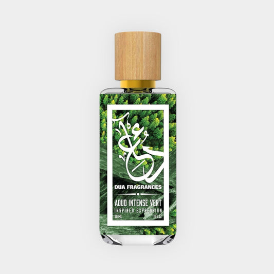 A bottle of DUA Aoud Intense Vert Sample, featuring a wooden cap and a vibrant green label, set against a backdrop of lush greenery. The fragrance is described as an inspired expression.