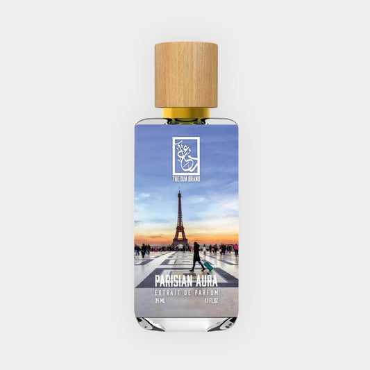 Dua Parisian Aura Sample, an elegant fragrance presented in a clear bottle featuring a wooden cap, with a picturesque image of the Eiffel Tower and a vibrant sunset backdrop.