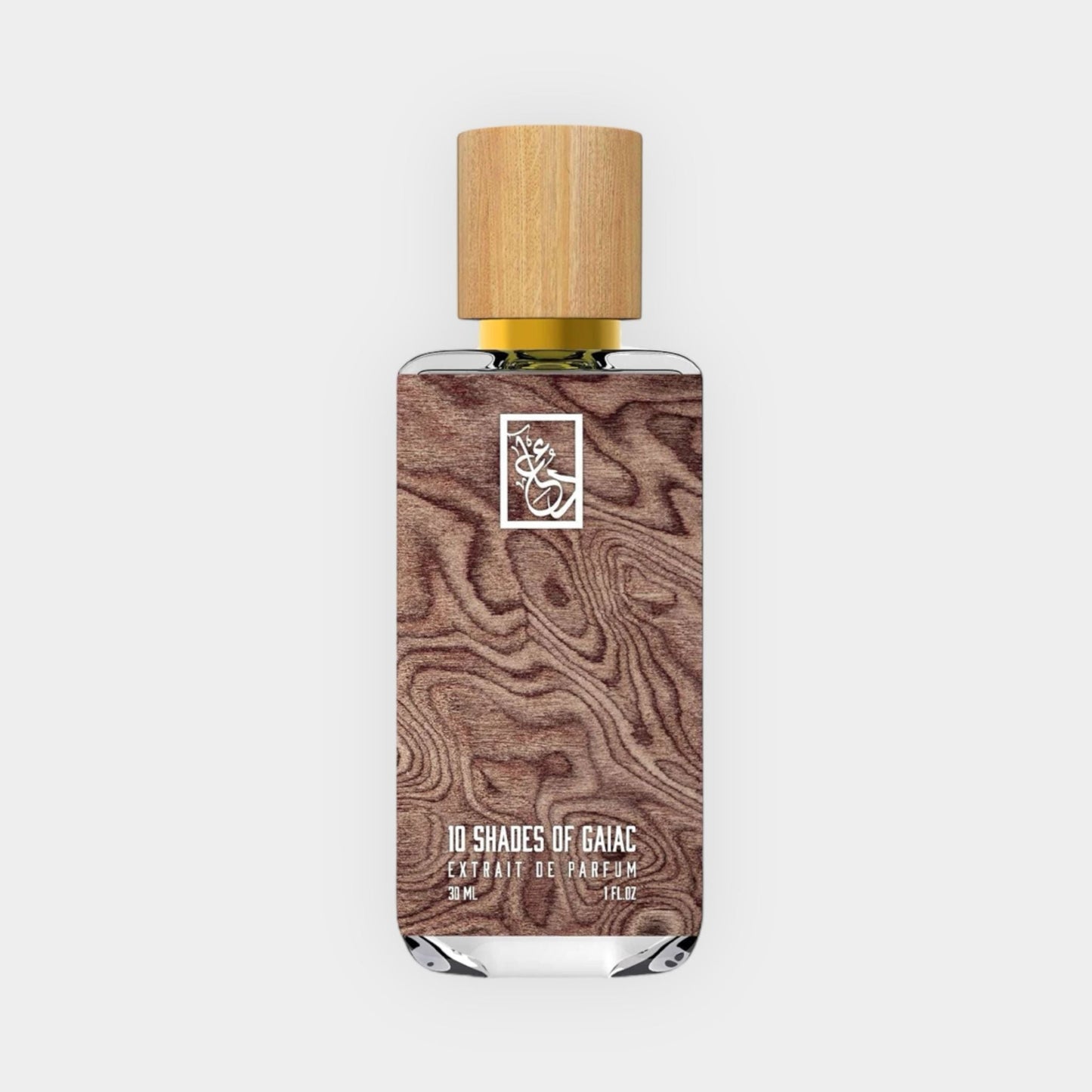 A bottle of Dua 10 Shades of Gaiac perfume, featuring a wooden cap and a sleek design with a textured wood background, contained in a 3 ml glass vial.
